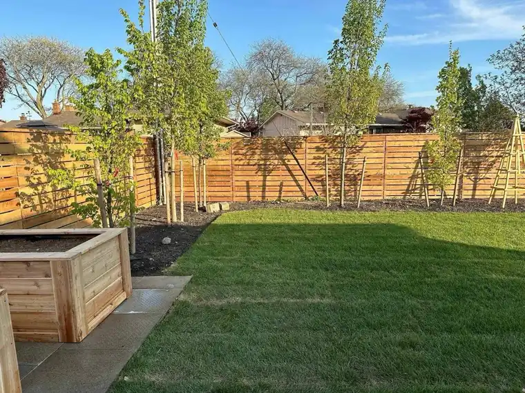 Completed horizontal wood fence enclosing a finished lawn